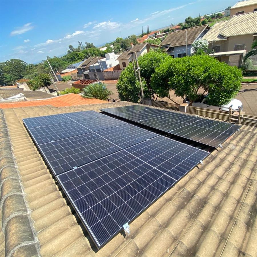 Sistema fotovoltaico instalado no telhado de uma residência, com painéis alinhados sobre as telhas